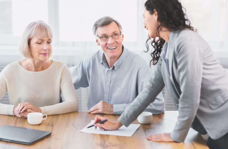 woman discussing a piece of paper with older couple